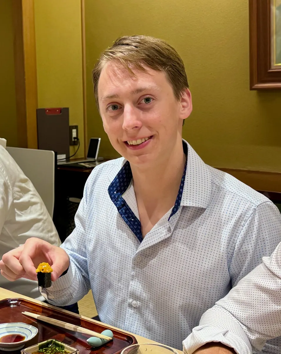 Sebastian eating sushi at a table in Japan