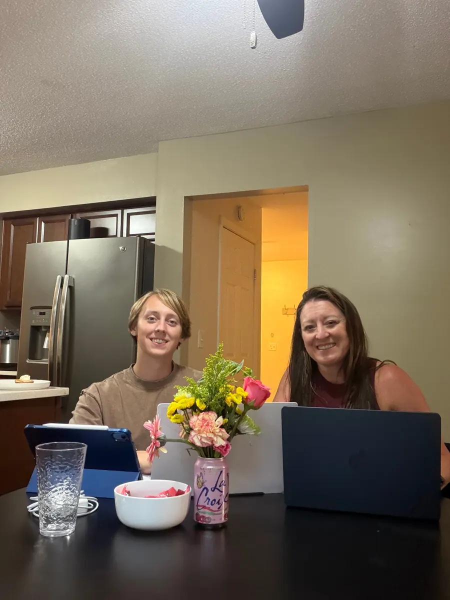 Sebastian and his mom working at laptops at the kitchen table